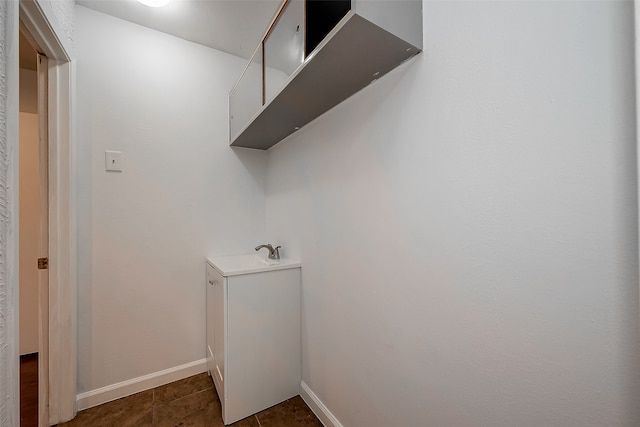 laundry room with sink and dark tile patterned flooring