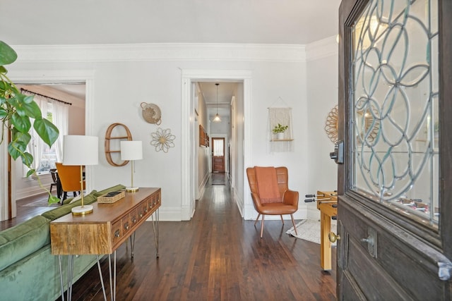 entrance foyer with dark wood-style floors, ornamental molding, and baseboards