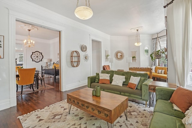 living room with an inviting chandelier, baseboards, ornamental molding, and wood finished floors