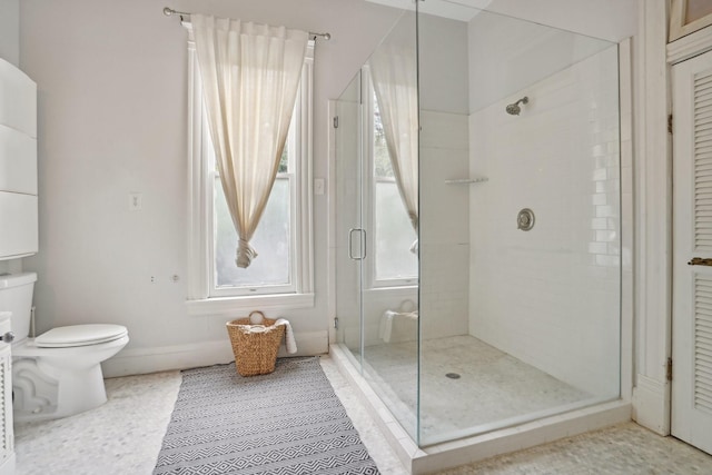 bathroom featuring toilet, a stall shower, tile patterned flooring, and baseboards