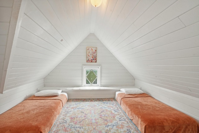 bedroom featuring lofted ceiling, wood walls, and wooden ceiling