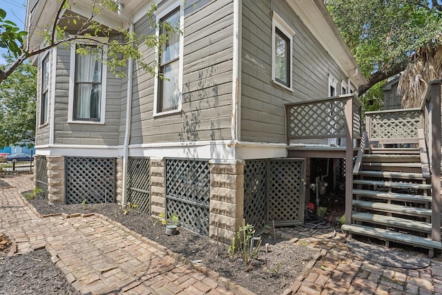 view of property exterior with stairs and a wooden deck