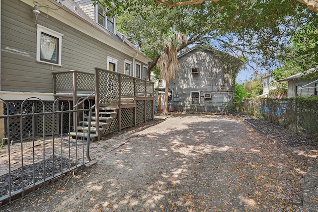 view of yard with a deck, fence, and stairs