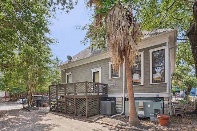 rear view of property with cooling unit and a wooden deck