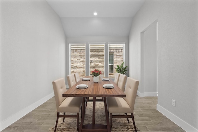 dining area with hardwood / wood-style floors and vaulted ceiling