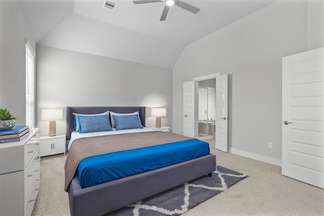 bedroom with connected bathroom, lofted ceiling, light carpet, and ceiling fan