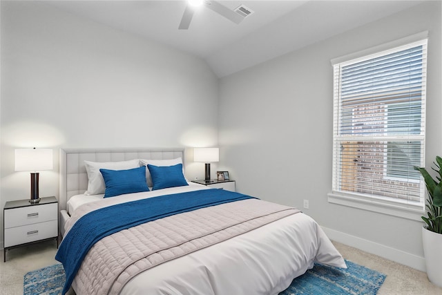 carpeted bedroom with ceiling fan and vaulted ceiling