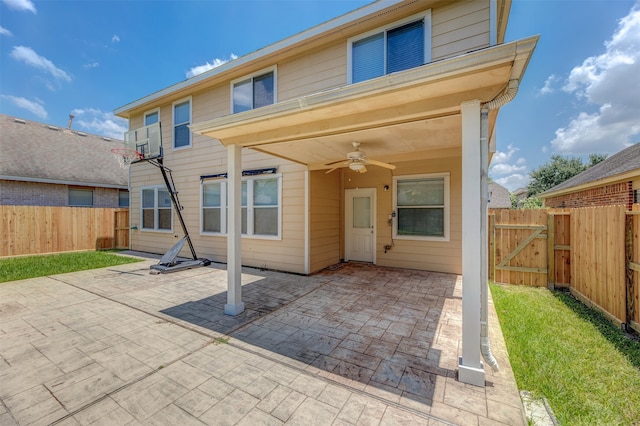 rear view of house featuring ceiling fan and a patio area