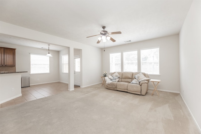 living room featuring ceiling fan, a healthy amount of sunlight, and light carpet