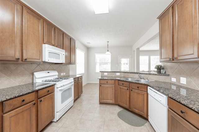 kitchen featuring white appliances, sink, dark stone counters, light tile patterned floors, and decorative backsplash