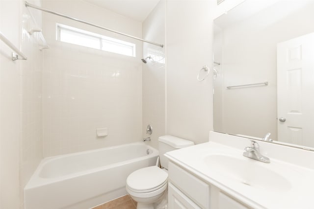 full bathroom with tile patterned floors, vanity, tiled shower / bath, and toilet