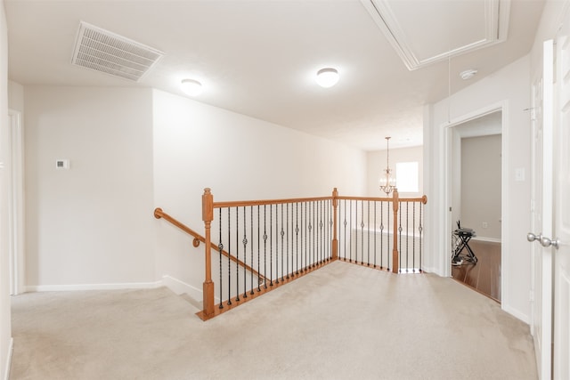 hallway featuring carpet flooring and a chandelier