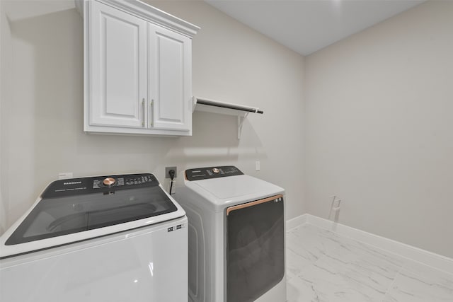 laundry room with washer and dryer, light tile patterned flooring, and cabinets