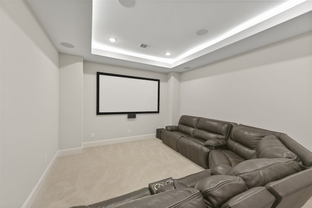 carpeted home theater room featuring a tray ceiling