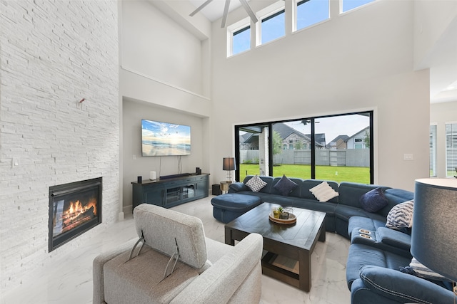 living room with a fireplace and a towering ceiling