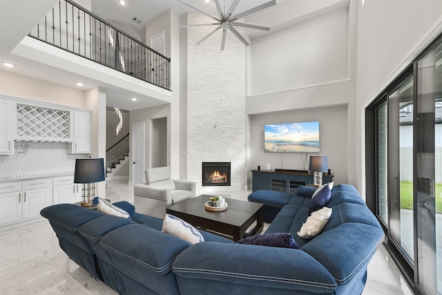 tiled living room with a fireplace and a high ceiling