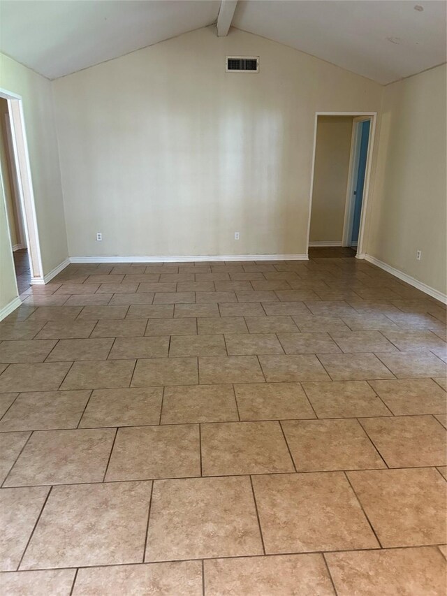 tiled spare room with lofted ceiling with beams