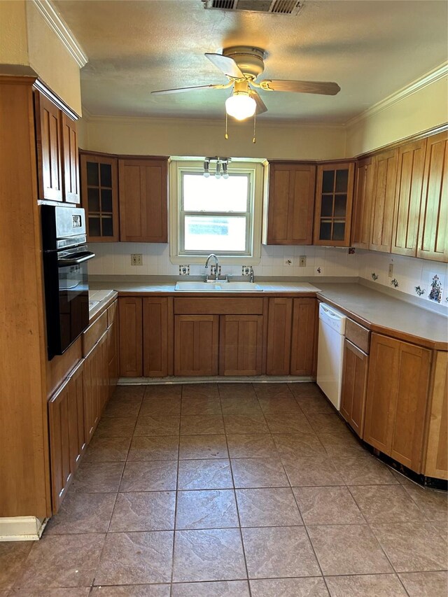 kitchen with light tile patterned floors, dishwasher, oven, ceiling fan, and sink