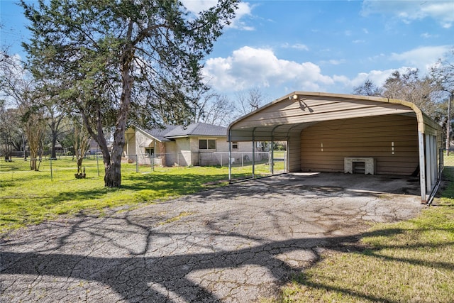 exterior space with a yard, driveway, fence, and a carport