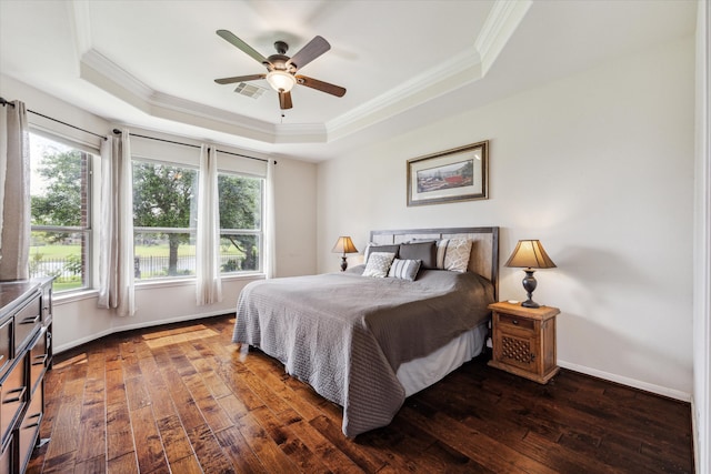 bedroom with wood-type flooring, a tray ceiling, ornamental molding, and ceiling fan