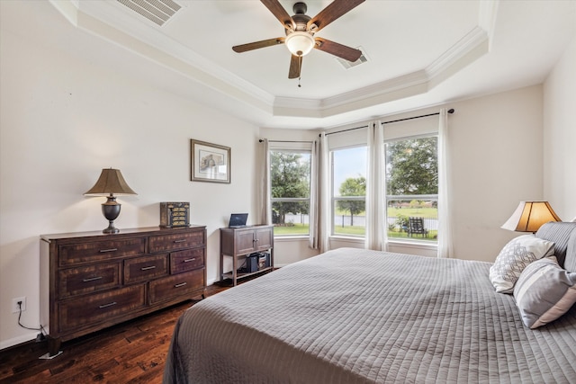 bedroom featuring ceiling fan, a raised ceiling, hardwood / wood-style floors, and crown molding