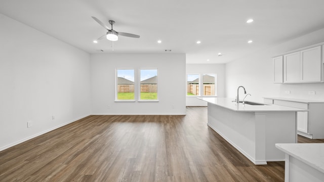 unfurnished living room with ceiling fan, dark hardwood / wood-style flooring, and sink