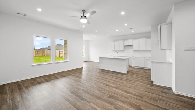 unfurnished living room with ceiling fan, dark hardwood / wood-style flooring, and sink