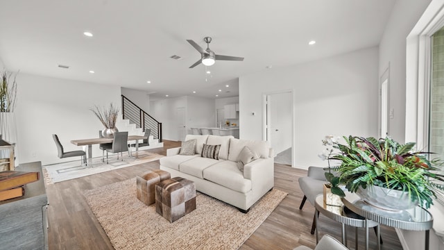 living room featuring light hardwood / wood-style floors and ceiling fan