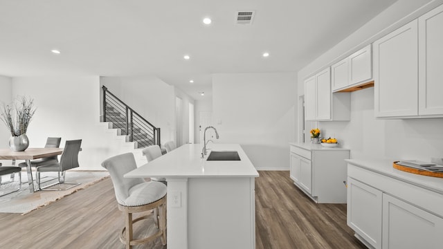 kitchen featuring white cabinetry, a kitchen island with sink, sink, and dark hardwood / wood-style floors