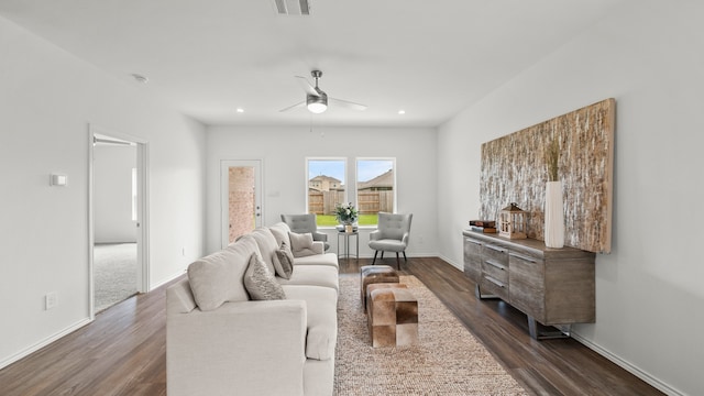 living room with ceiling fan and dark hardwood / wood-style flooring