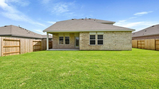 back of property with a lawn and a patio area