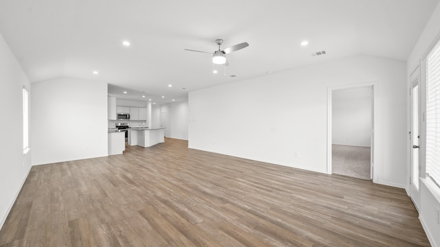 unfurnished living room featuring light hardwood / wood-style flooring, lofted ceiling, and ceiling fan