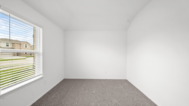 carpeted spare room with lofted ceiling