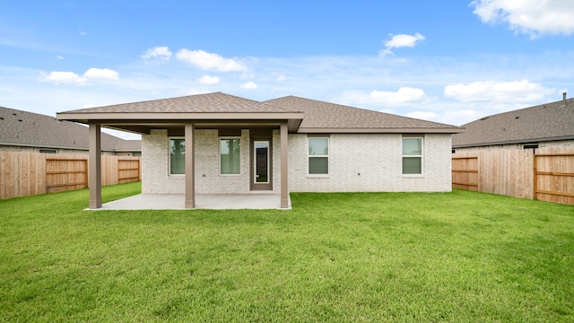 rear view of house featuring a patio and a yard