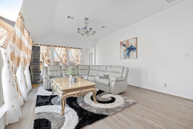 living room featuring an inviting chandelier, light hardwood / wood-style flooring, and lofted ceiling