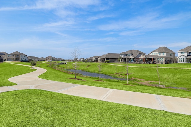 view of community with a water view and a lawn