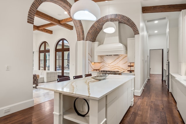 kitchen featuring a wealth of natural light, a kitchen island, and dark hardwood / wood-style floors