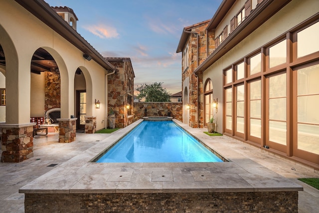 pool at dusk with a patio