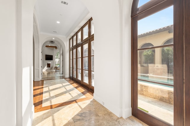 foyer entrance with crown molding and plenty of natural light