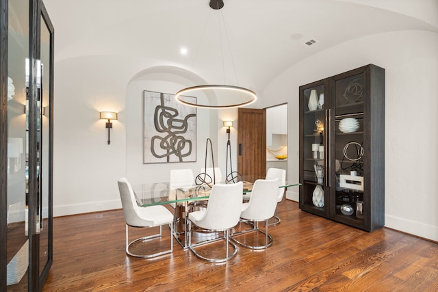 dining area with dark hardwood / wood-style flooring and lofted ceiling