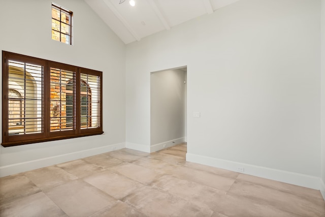 spare room featuring high vaulted ceiling and beam ceiling