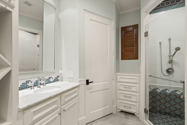 bathroom with crown molding, vanity, a shower with shower door, and decorative backsplash