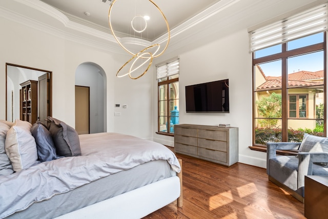 bedroom with a tray ceiling, multiple windows, crown molding, and hardwood / wood-style floors