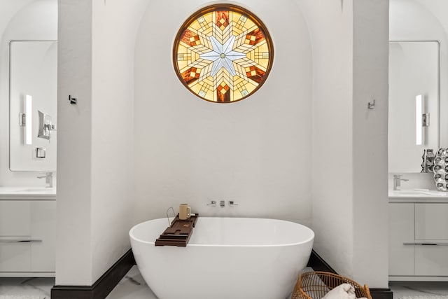 bathroom featuring vanity and a washtub