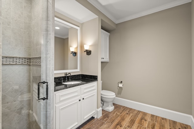 bathroom featuring crown molding, toilet, a shower, wood-type flooring, and vanity