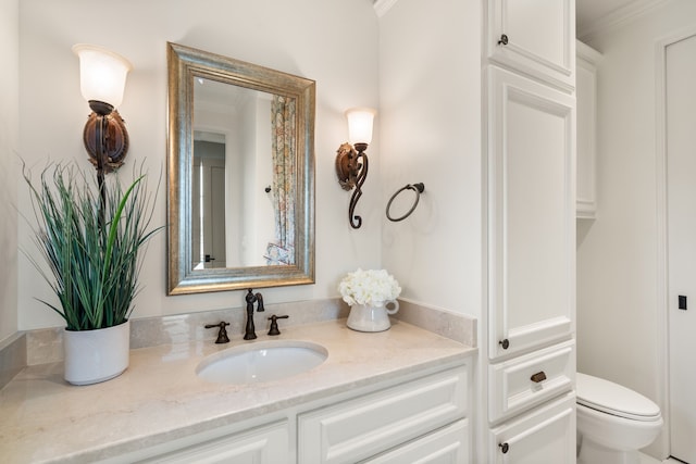 bathroom with crown molding, vanity, and toilet