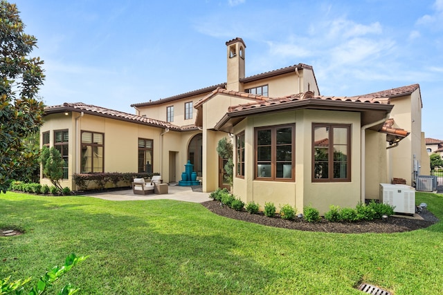 back of house featuring an outdoor living space, a patio area, a lawn, and central air condition unit