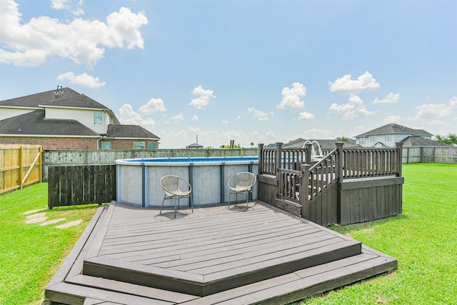 wooden terrace with a fenced in pool and a lawn