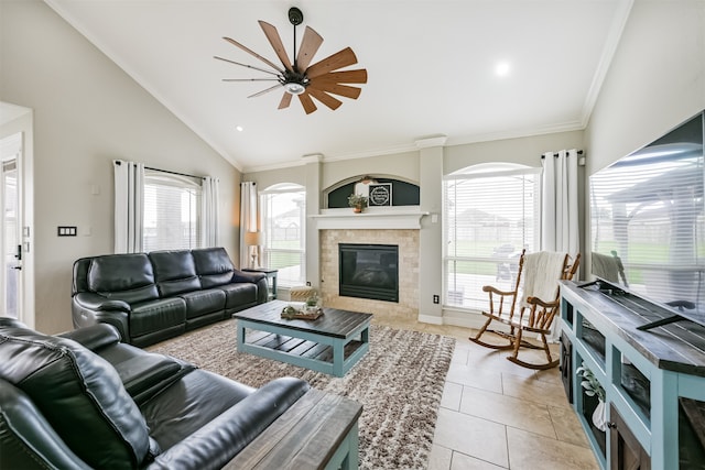 tiled living room featuring ornamental molding, ceiling fan, a tiled fireplace, and vaulted ceiling