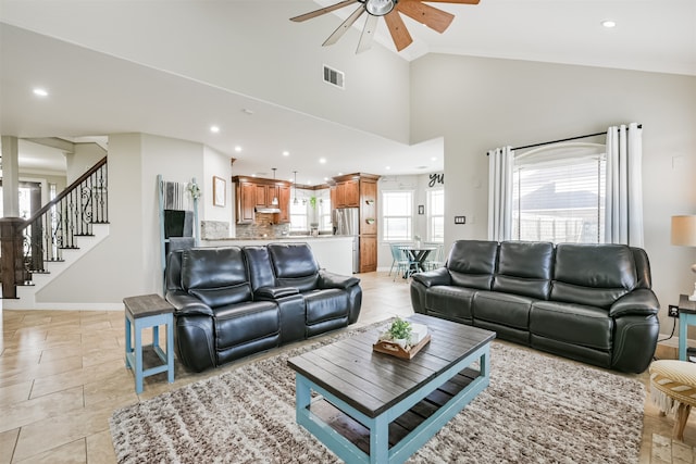 living room with ceiling fan and high vaulted ceiling